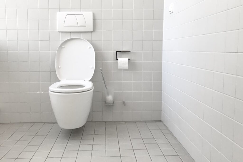WC suspendu blanc dans une salle de bain carrelée
