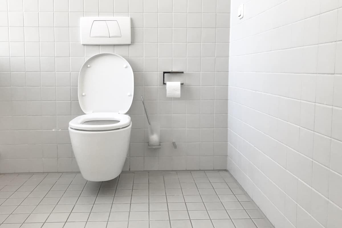 WC suspendu blanc dans une salle de bain carrelée